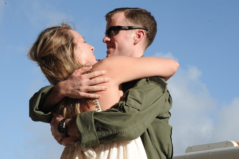 U.S. Navy Lt. Gatlin Hardin, Helicopter Sea Combat Squadron TWO FIVE, Detachment SIX helicopter aircraft commander, hugs his wife during the detachment’s homecoming at Andersen Air Force Base, Guam, Dec. 17, 2012. The detachment was deployed aboard the USS Bonhomme Richard (LHD 6) and operated out of Marine Corps Air Station, Iwakuni, Japan, and Kadena Air Base, Japan.  The deployment enabled the squadron’s first use of a three-aircraft detachment supporting numerous missions in support of the certification exercises for the 31st Marine Expeditionary Unit, Camp Hansen, Okinawa, Japan, and the Philippine bilateral exercise. (U.S. Air Force photo by Airman 1st Class Adarius Petty/Released)