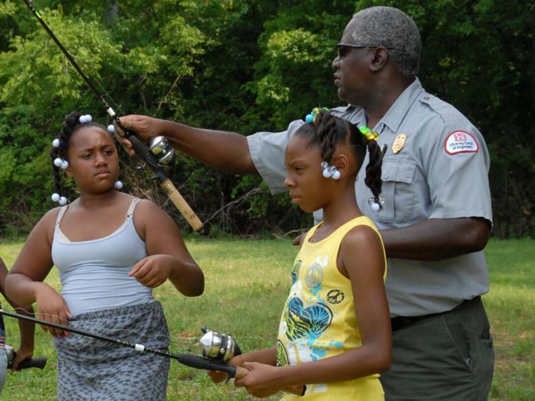 Park Ranger Robert Davis helps Aniya Young (Left), 8, and Unique Henderson, 10, with their fishing poles during a fishing rodeo held June 14, 2011 at Cook Recreation Area located at J. Percy Priest Lake in Hermitage, Tenn.  The kids from the Hermitage Community Center enjoyed a day of fishing and learned about water safety. (USACE photo by Michael Rivera)