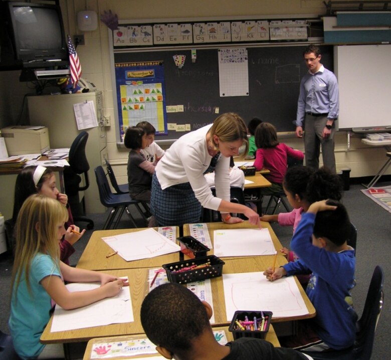 Nicole Wayant, a Topographic Engineering Center geographer and mathematician, works with students in their classroom during an earlier ERDC Geographic Information Systems Day.
