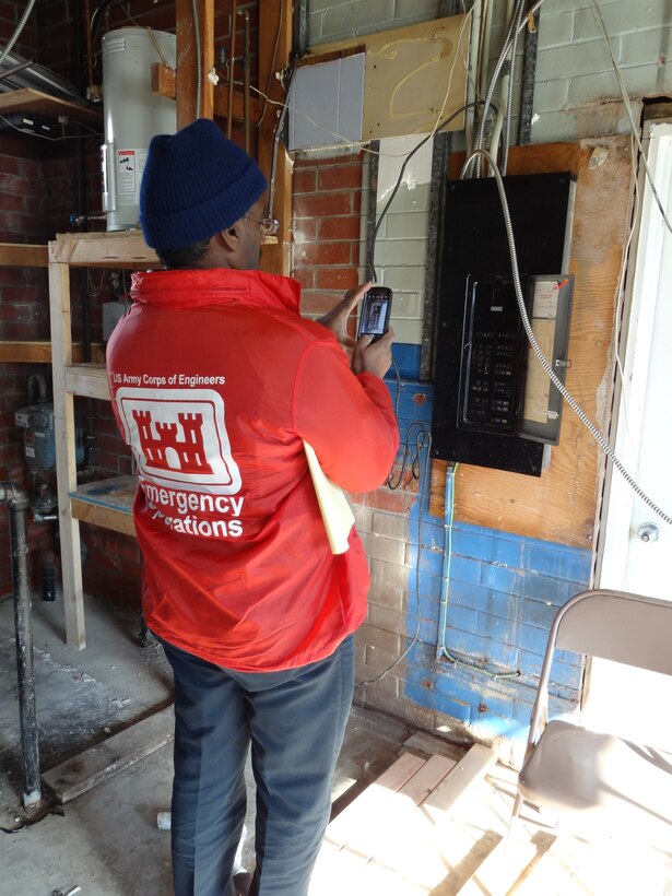 Gerald DeLoach, electrical engineer, inspects the circuit box at the Moonachie First Aid and Rescue Squad's headquarters, Moonachie, N.J., during a visit to assess the need for temporary facilities for the squad.