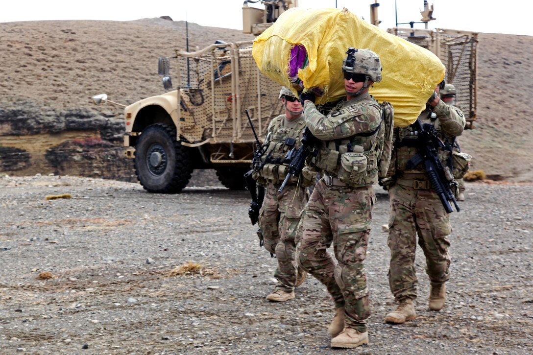 U.S. Army Spc. Jose Colon and U.S. Army Sgt. Brian Wimer carry a load of blankets for Afghan police to distribute to local citizens in Khoni Kwar village in Afghanistan's Khowst province, Dec. 14, 2012. Colon and Wimer are assigned to Company A, 3rd Special Troops Battalion.