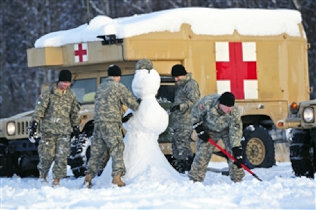 Pfc. Christopher Moore, left, Pvt. Jordan Villa, second from left, Sgt. John-Paul Gorcyca, second from right, and Pfc. Sean Spacek, right, build a snowman at Malamute Drop Zone on Joint Base Elmendorf-Richardson while waiting for a parachute drop of heavy equipment, on Dec. 13, 2012.   The soldiers are assigned to the 6th Engineer Battalion.  