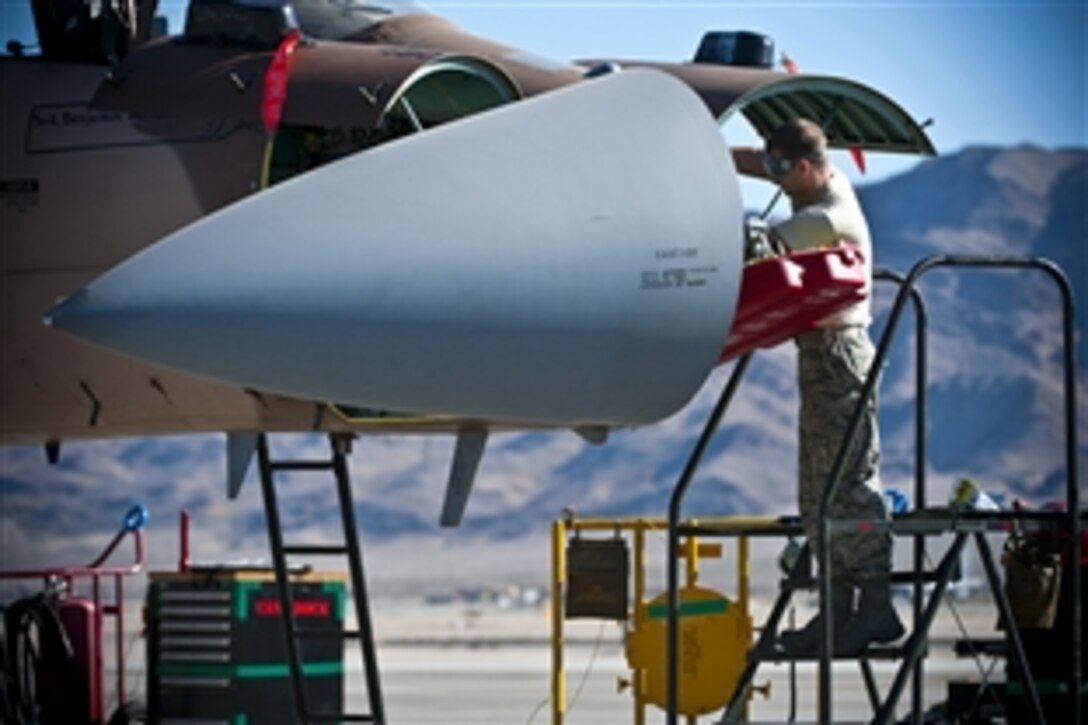 Air Force Sr. Airman Brion Humenay works on the nose of an F-15 Eagle during a mission employment phase exercise on Nellis Air Force Base, Nev., Dec. 7, 2012. Mays, an avionics specialist, is assigned to the 926th Aircraft Maintenance Squadron.