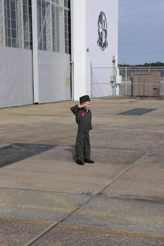 The son of a KC-130J Hercules pilot with Marine Aerial Refueler Transport Squadron 252, salutes two KC-130J Hercules as the aircraft land Dec. 15 at Cherry Point. 