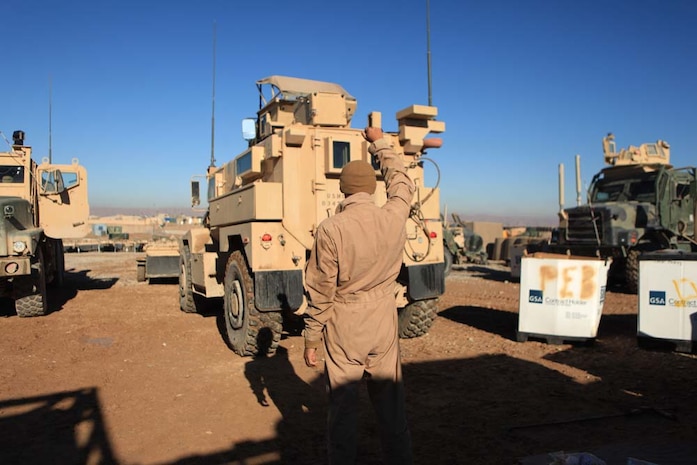 Lance Cpl. Victor LopezVega halts a vehicle in the motor transport lot aboard Combat Outpost Shamsher, Afghanistan, Dec. 19, 2012. As a motor transport mechanic, LopezVega is one of the many Marines with the motor transport section of Headquarters and Service Company, 2nd Battalion, 7th Marines, Regimental Combat Team 7, who work together to maintain equipment and deliver supplies throughout northern Helmand province.