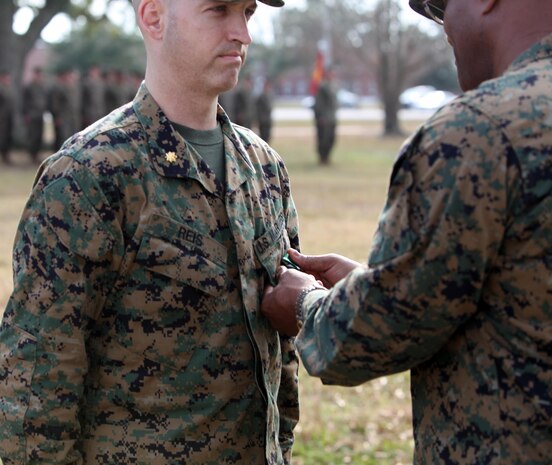 Col. Dwayne A. Whiteside (center), the commanding officer of Combat Logistics Regiment 2, 2nd Marine Logistics Group, pins a Navy and Marine Corps Commendation Medal on the chest of Maj. Matthew D. Reis, the adjutant of CLR-2, during a ceremony Dec. 11, 2012, aboard Camp Lejeune, N.C. Reis received the award for his exceptional situational awareness and immediate action while responding to a disturbance at a nearby barracks.