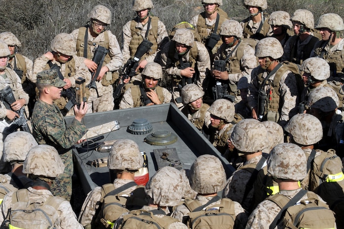 Recruits of Company I, 3rd Recruit Training Battalion, gather around a field instructor as he shows examples of improvised explosive devices at the end of the IED lane at Edson Range aboard Marine Corps Base Camp Pendleton, Calif. Dec. 11. Recruits are educated on different examples of IEDS they could encounter during a deployment.  