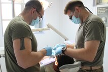 A patient is looked over by Seaman Joshua M Dalton, left,  and Lt. Cmdr. Michael Flannery at the Tinian Health Center Dec. 3. The Navy medical personnel will be on Tinian for the duration of Exercise Forager Fury 2012 to assist with the medical and dental needs of the local community. Dalton is an oral surgical technician and Flannery a general dentist for 11th Dental Company, 3rd Dental Battalion, 3rd Marine Logistics Group, III Marine Expeditionary Force.
