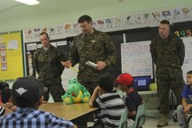 Lt. Cmdr. Michael Flannery, center, and Seamen Joshua M. Dalton, left, and Jeffrey M. Ker give a class on proper dental hygiene at the Tinian Elementary School here Dec. 5. The class was given to further educate children on the importance of oral hygiene at a young age. After the class toothbrushes and floss were passed out to the children. Flannery is a general dentist; Ker is a dental technician; and Dalton is an oral surgical technician with 11th Dental Company, 3rd Dental Battalion, 3rd Marine Logistics Group, III Marine Expeditionary Force.