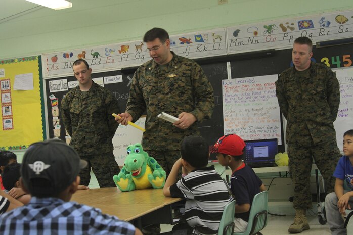 Lt. Cmdr. Michael Flannery, center, and Seamen Joshua M. Dalton, left, and Jeffrey M. Ker give a class on proper dental hygiene at the Tinian Elementary School here Dec. 5. The class was given to further educate children on the importance of oral hygiene at a young age. After the class toothbrushes and floss were passed out to the children. Flannery is a general dentist; Ker is a dental technician; and Dalton is an oral surgical technician with 11th Dental Company, 3rd Dental Battalion, 3rd Marine Logistics Group, III Marine Expeditionary Force.
