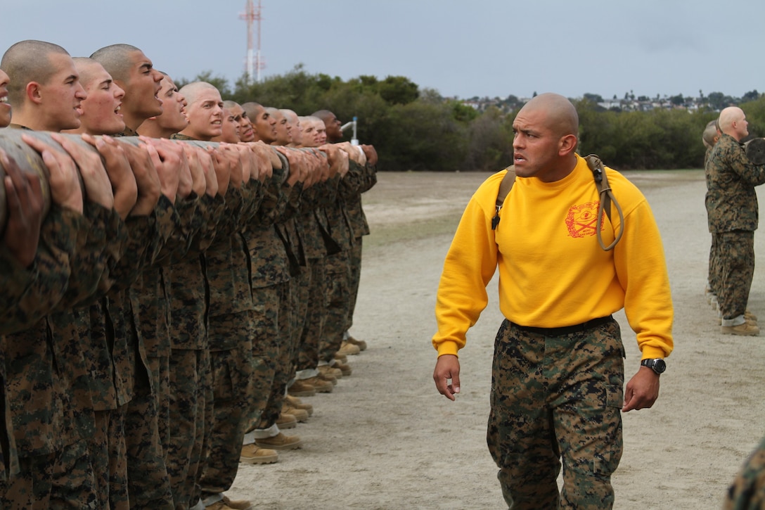 Sgt. Mark Garcia, senior drill instructor, Platoon 2143, Company G, 2nd Recruit Training Battalion, instructs his recruits to perform curls with a log weighing more than 250 pounds during log drills aboard Marine Corps Recruit Depot San Diego Dec. 18. Log drills is an event that requires to work together carrying a log around for half a mile.