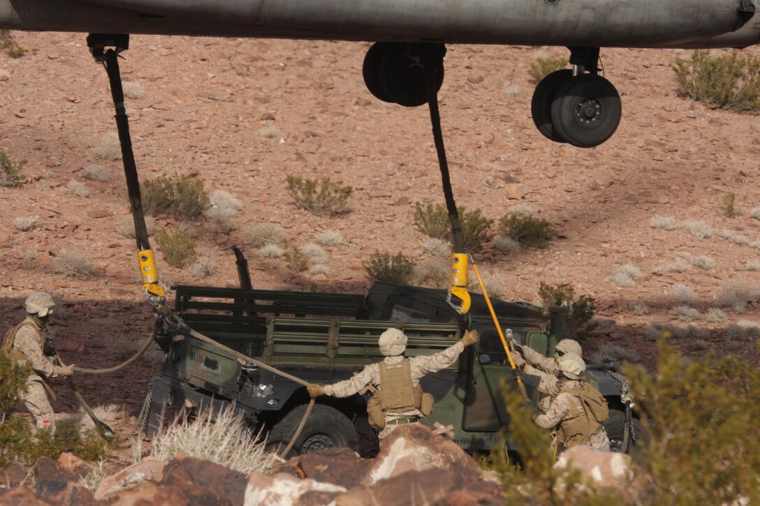Marines with Combat Logistics Battalion 5, 1st Combat Logistic Group and 1st Marine Expeditionary Force connect a Humvee to a Marine Heavy Helicopter Squadron 465 Super Stallion during the Steel Knight exercise aboard Marine Corps Air Ground Combat Center, Twentynine Palms, Calif., Dec. 14. Pilots and crew chiefs with HMH-465 preformed external lifts to take supplies and vehicles out of the hills and uneven terrain of Twentynine Palms.      