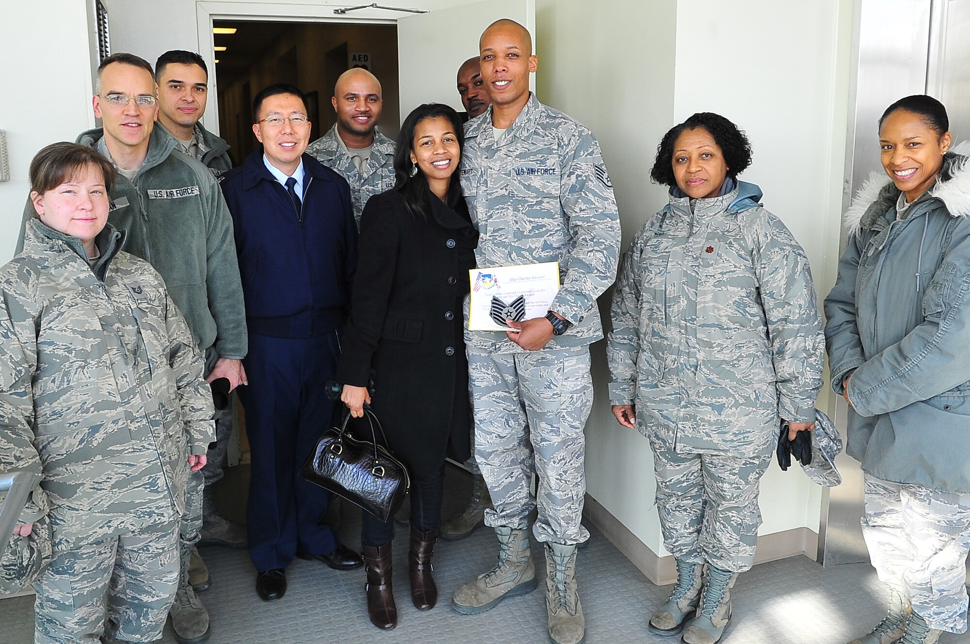 Tech. Sgt. Charles Stewart, 51st Fighter Wing Chapel chaplain assistant, poses with his wife and co-workers after being promoted through the Stripes for Exceptional Performers program at the 51st FW headquarters, Dec. 18, 2012 at Osan Air Base, Republic of Korea. The STEP program allows major commands, field operating agencies, direct reporting unit commanders, and senior Air Force officers with large enlisted populations to select a limited number of Airmen with exceptional potential for promotion to the grades of staff sergeant through master sergeant. (U.S. Air Force photo/Tech. Sgt. Raymond Mills) 