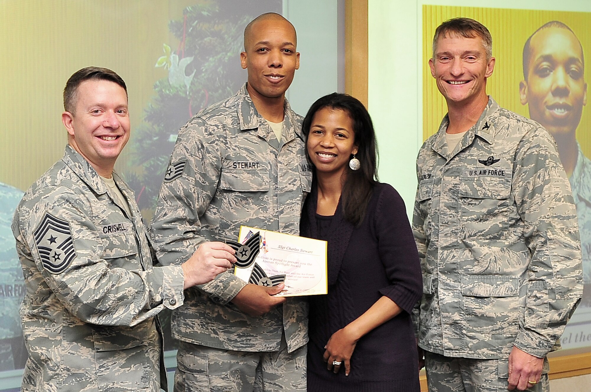 Tech. Sgt. Charles Stewart, 51st Fighter Wing Chapel chaplain assistant, poses with his wife, Myeshia Stewart, Col. Patrick McKenzie, 51st FW commander, and Chief Master Sgt. Brendan Criswell, 51st FW command chief after being promoted to technical sergeant through Stripes for Exceptional Performance at a presentation held at the wing headquarters Dec. 18, 2012 at Osan Air Base, Republic of Korea. The STEP program allows major commands, field operating agencies, direct reporting unit commanders, and senior Air Force officers with large enlisted populations to select a limited number of Airmen with exceptional potential for promotion to the grades of staff sergeant through master sergeant. (U.S. Air Force photo/Tech. Sgt. Raymond Mills)