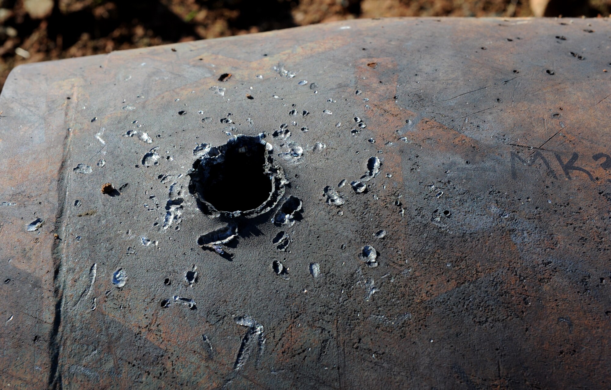 Inert ordnance is damaged by a shaped charge at the explosive ordinance disposal range on Beale Air Force Base, Calif., Dec. 19, 2012. EOD Airmen often train with different explosives to see the blasting effects. (U.S. Air Force photo by Staff Sgt. Robert M. Trujillo/Released)
