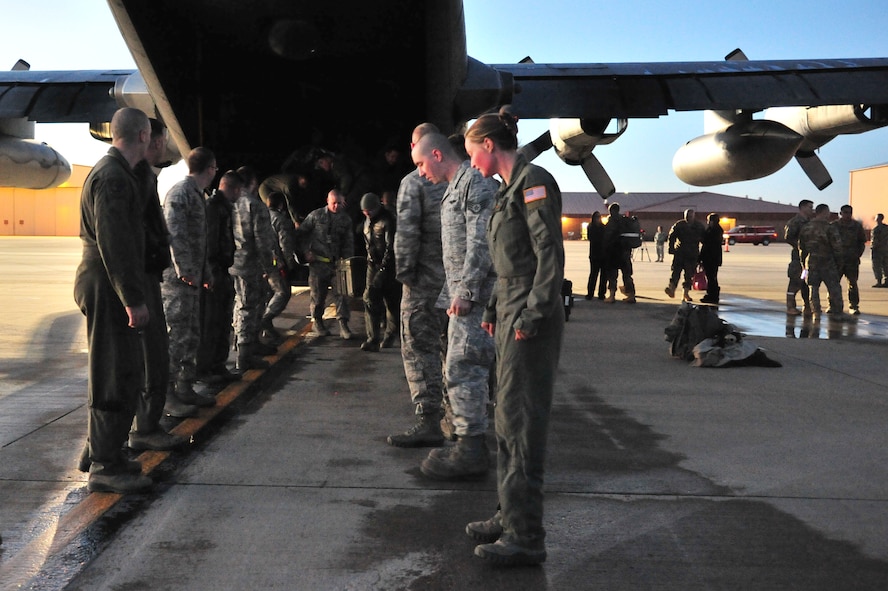 A group of Air Commandos assemble to unload cargo from an AC-130H Spectre gunship on the flightline at Cannon Air Force Base, N.M., Dec. 20, 2012. The arrival of this gunship marked the first time in more than eight years that the entire fleet has been home stateside. (U.S. Air Force photo/Senior Airman Alexxis Pons Abascal) 