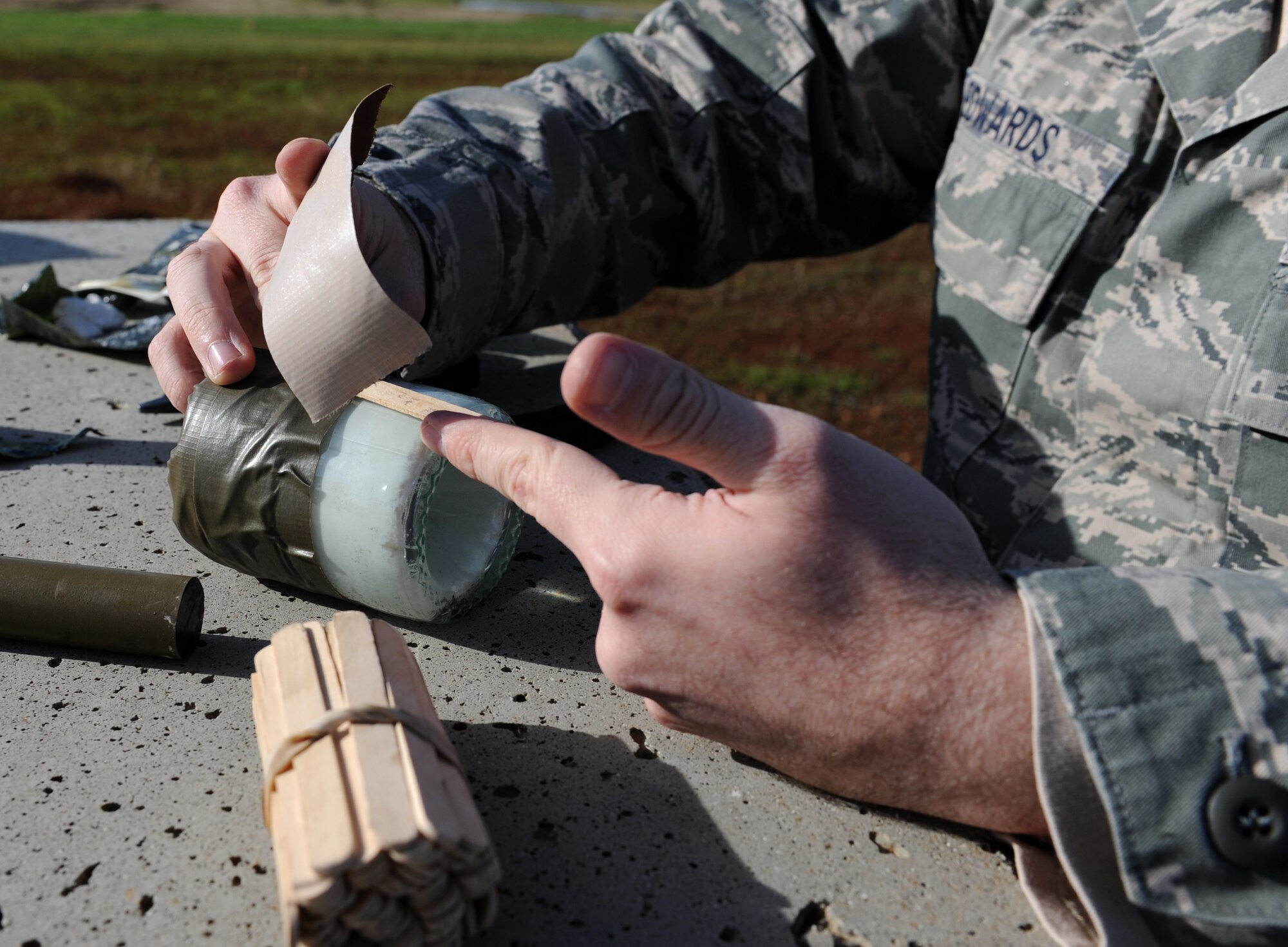 Senior Airman Kile Edwards, 9th Civil Engineer Squadron explosive ordinance disposal technicians prepares a shaped charge explosive using a glass bottle during a training scenario at the EOD range on Beale Air Force Base, Calif., Dec. 19, 2012. EOD Airmen train with different types of explosives to simulate what they may encounter in the field. (U.S. Air Force photo by Staff Sgt. Robert M. Trujillo/Released)