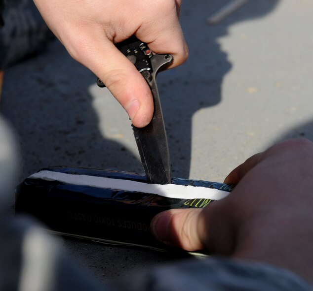 Staff Sgt. Daniel Johnsen, 9th Civil Engineer Squadron explosive ordnance disposal technician, uses a knife to form a block of C4 explosive during a training scenario at the EOD range on Beale Air Force Base, Calif., Dec. 19, 2012. EOD Airmen train with different types of explosives to simulate what they may encounter in the field. (U.S. Air Force photo by Staff Sgt. Robert M. Trujillo/Released)