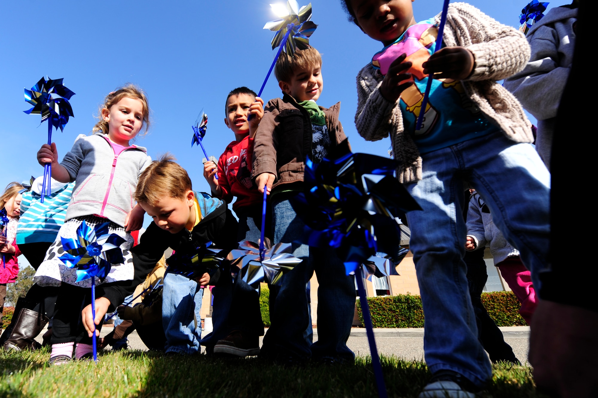 VANDENBERG AIR FORCE BASE, Calif. -- Children from the Child Development Center plant pinwheels in front of the CDC during the Child Abuse Prevention Month campaign here Monday, Apr. 9, 2012. National Child Abuse Prevention month focuses on promoting awareness for child safety to prevent abuse and neglect toward children. (U.S. Air Force photo/Staff Sgt. Andrew Satran) 