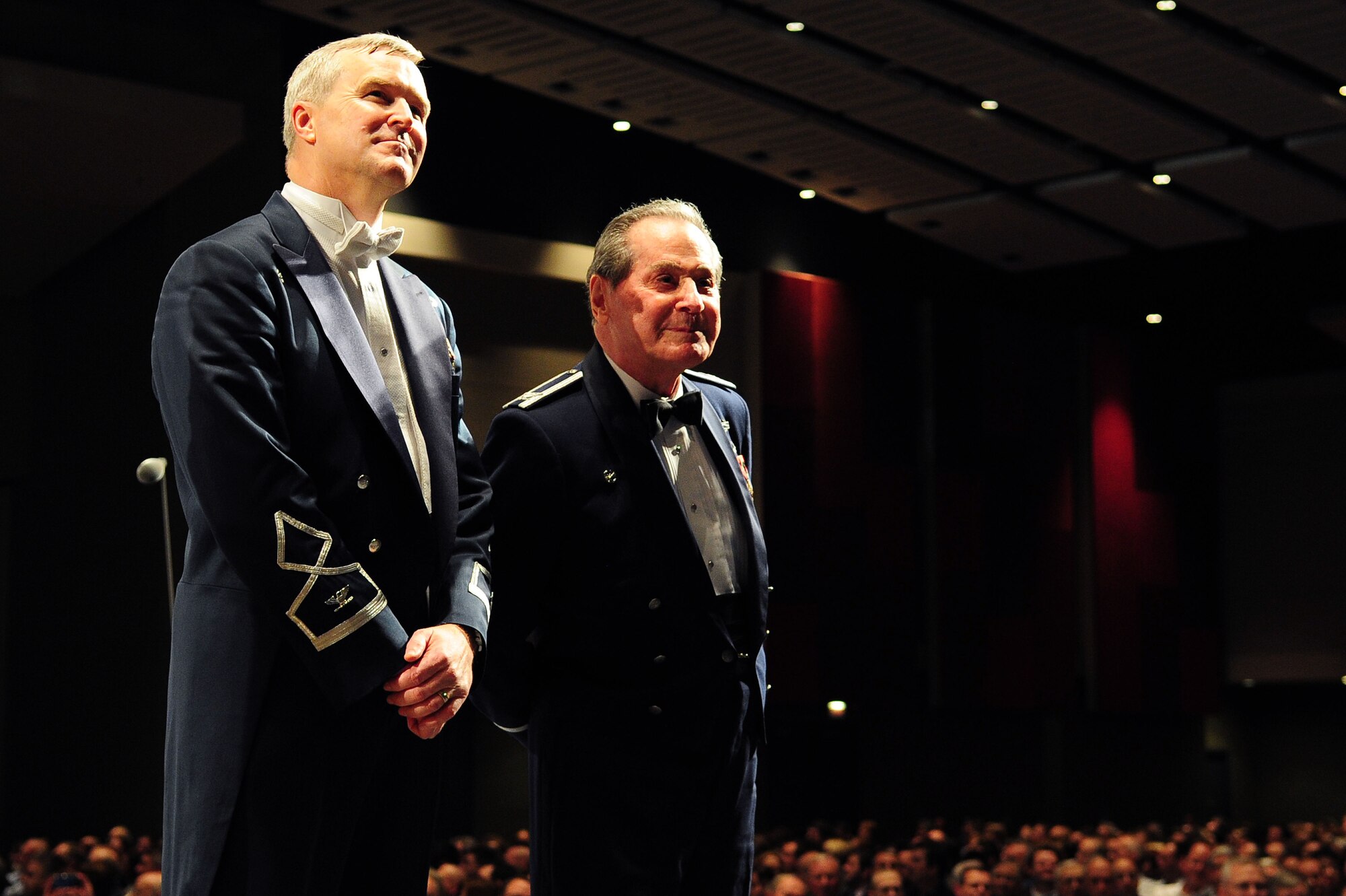 U.S. Air Force Band Commander Col. Larry Lang and Col. Arnald Gabriel (Ret.), USAF Band commander 1964-1985, watch a video tribute dedicated to Gabriel during a performance at the 66th Annual Midwest Clinic, Dec. 19, in Chicago, Ill. "The spirit, musicianship and enthusiasm--it's a tribute to what we're doing in our universities across the nation. The teaching is better than ever; so the bands and the Airmen themselves are playing better than ever." Gabriel was presented the Midwest Clinic Medal of Honor during the final performance. (U.S. Air Force photo by Senior Airman Steele C. G. Britton)