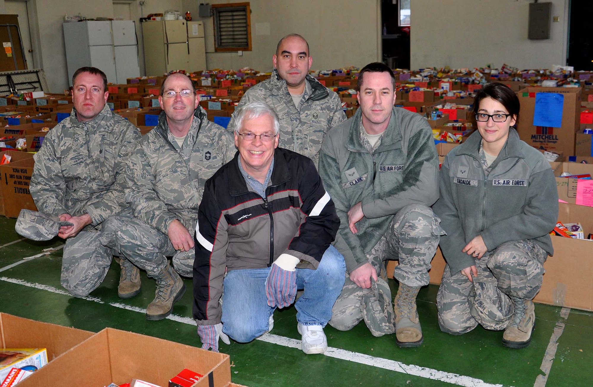 From back and left, Tech Sgt. Loren Wells from the 446th Force Support Squadron, Chief Master Sgt. Chris Dietz from the 86th Aerial Port Squadron, Master Sgt. David Panelo from the 313th Airlift Squadron, Airman 1st Class Kevin Clark from the 446th Aircraft Maintenance Squadron and Senior Airman Sarah Fagalde from the 446th Aircraft Maintenance Squadron pose for the camera with Carl Supplee, director of the 446th Force Support Squadron Airman and Family Readiness Center on Dec. 19 at the Central Pierce County Fire Department. They are posing in front of the 370 Christmas baskets that are going out to families in the area this holiday. The team just finished loading up the Christmas boxes that go to Reservist families at McChord Field. (U.S. Air Force Photo/Airman 1st Class Madelyn McCullough)