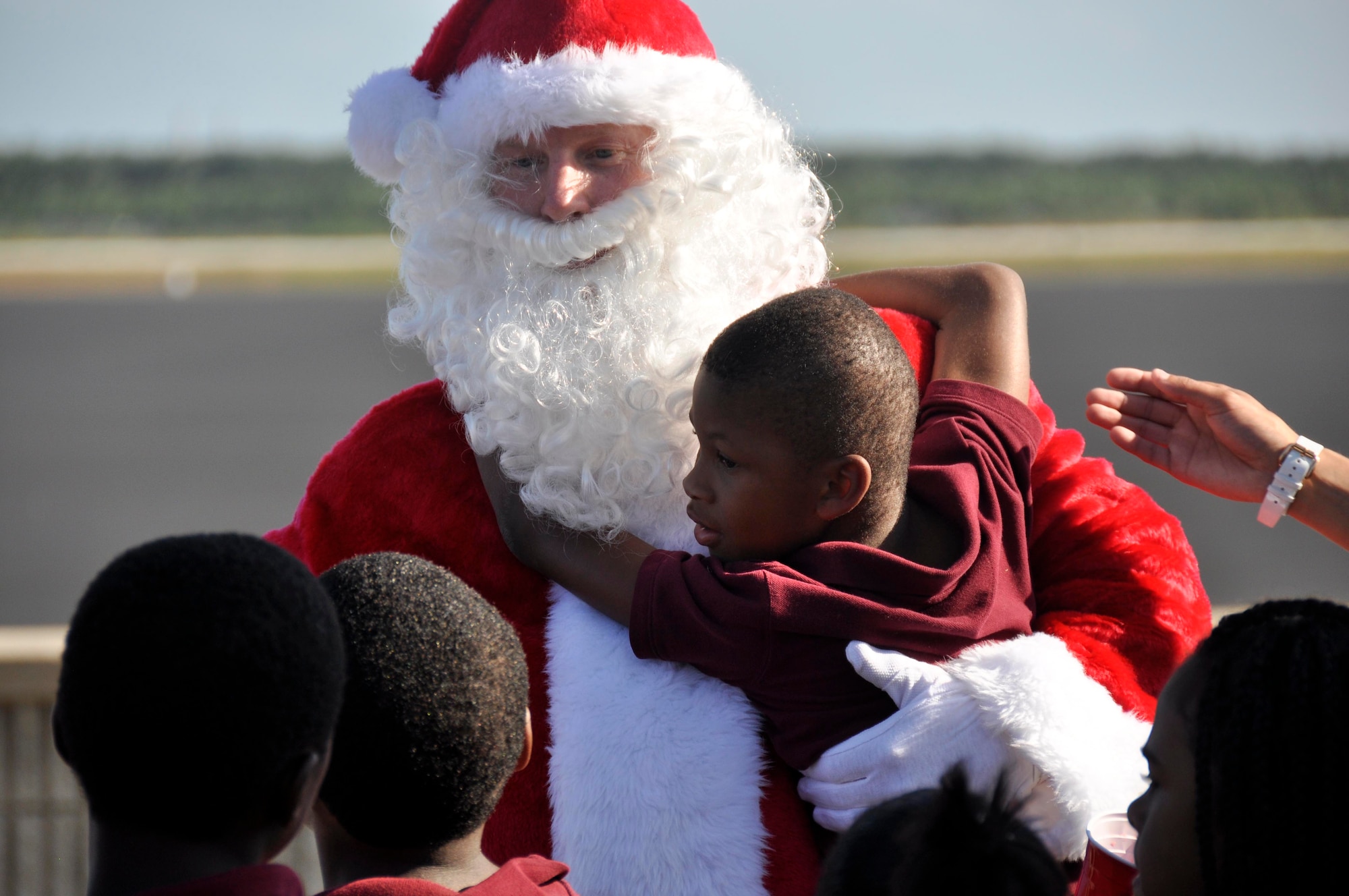 Santa Claus greets and embraces children involved with Chapman Partnership after arriving in an F-16 at Homestead Air Reserve Base, Fla., Dec. 19. Chapman Partnership, a local organization helping to combat homelessness, provides comprehensive services to empower homeless residents to become self-sufficient. Homestead ARB has also participated with Chapman Partnership on other events such as food drives. (U.S. Air Force photo/Senior Airman Jacob Jimenez)