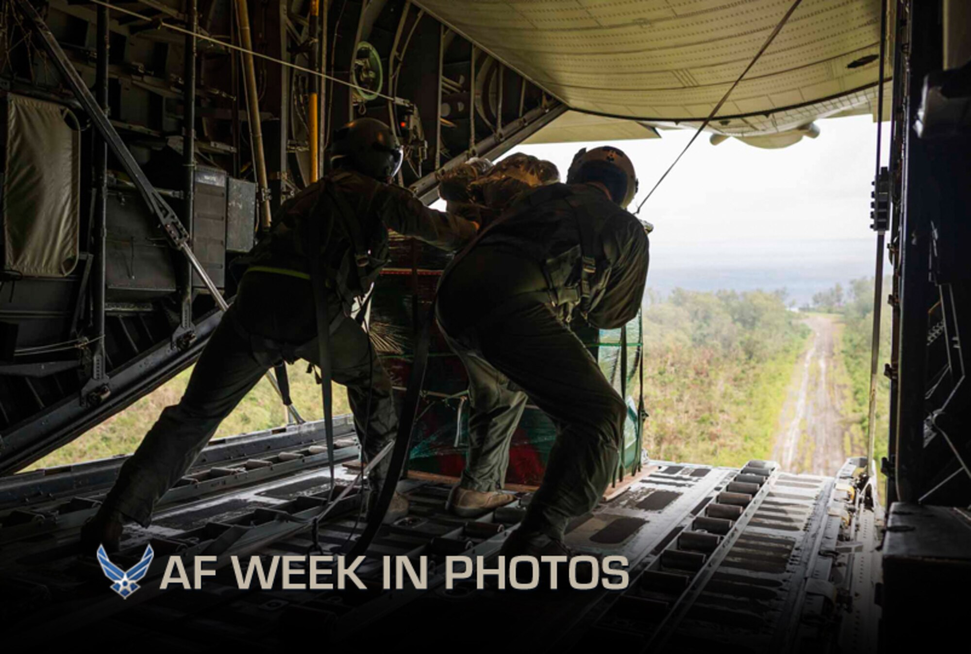 Senior Airman Timothy Oberman (left) and Capt. Ryan Turonek push a bundle of humanitarian aid items out of a C-130 Hercules aircraft over an island in the Pacific Ocean during Operation Christmas Drop, Dec. 13, 2012. Christmas Drop is an annual effort by Airmen at Yokota Air Base, Japan, and Andersen Air Force Base, Guam. During the operation Airmen deliver donated goods to more than 30,000 islanders in the Federated States of Micronesia, the Marshall Islands and the Commonwealth of the Northern Mariana Islands. This year, Airmen delivered 115 bundles of goods to 54 islands. Oberman and Turonek are assigned to the 36th Airlift Squadron at Yokota AB. (U.S. Air Force photo/Tech. Sgt. Samuel Morse)