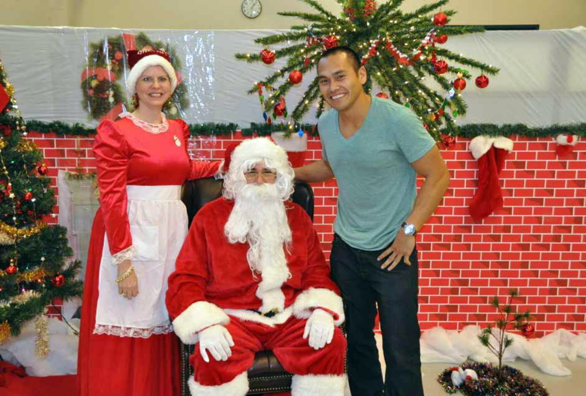 The 452d Maintenance Group and Maintenance Operations Squadron held their annual holiday party on Dec. 8. Unit family members joined in the festivities and enjoyed a magician, arts and crafts and delicious food. Pictured are Master Sgt. Arthur Lundgren as Santa, Tech. Sgt. Jill Lundgren as Mrs. Claus and Tech. Sgt. Allan Miller poses for a picture before telling Santa what he wants for Christmas this year. (U.S. Air Force photo by Chief Master Sgt. Jose Hinojosa)