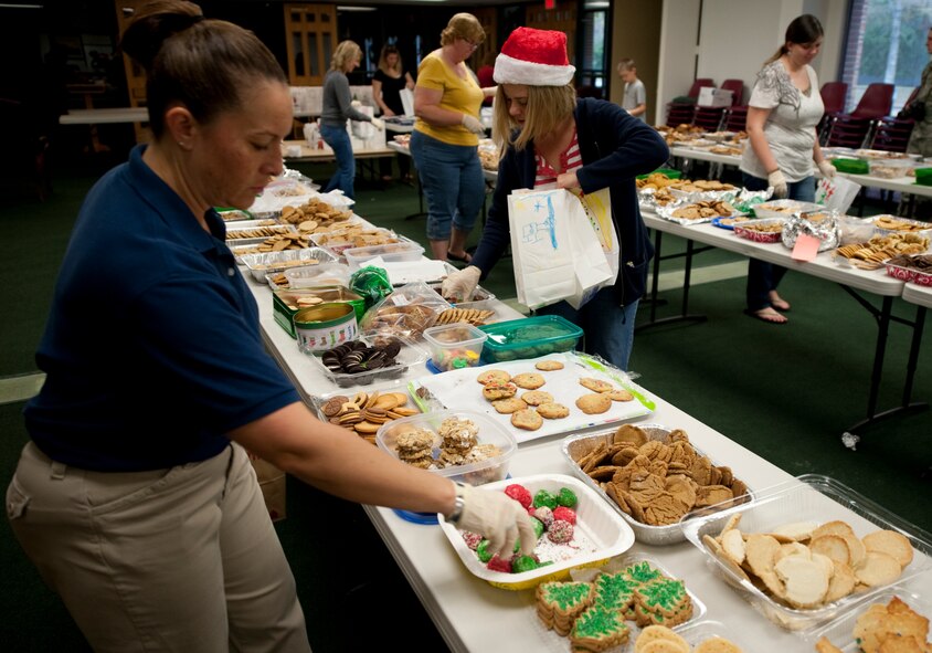Volunteers from the Hurlburt Spouses Club pick cookies from more than a dozen assortments of baked goods to place in decorated paper bags during preparations for the annual Commando Cookie Drop on Hurlburt Field, Fla., Dec. 17, 2012. Volunteers divided more than 15,000 cookies into approximately 1,200 bags to be presented to single Airmen who live in the on-base dormitories.  (U.S. photo by Senior Airman Kentavist P. Brackin)