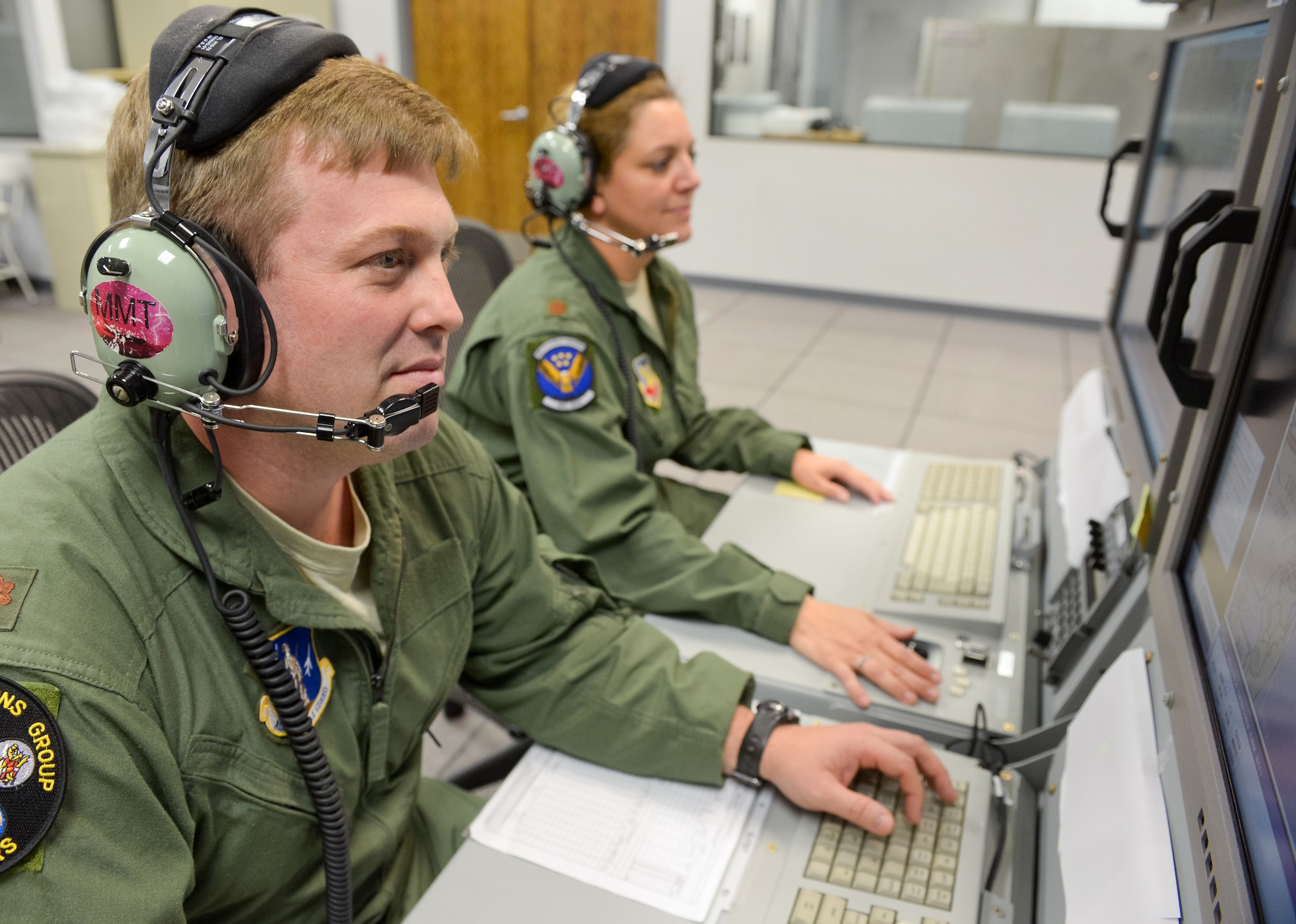 Air National Guard Maj. Sean, 116th Operations Group, and U.S. Air Force Maj. Melody, 461st Operations Support Squadron, monitor data at an operator work station in the Joint STARS mission simulator at Robins Air Force Base, Ga.  Team JSTARS reached a milestone logging more than 40,000 training hours in the mission simulator during the past 10 years. (National Guard photo by Master Sgt. Roger Parsons)