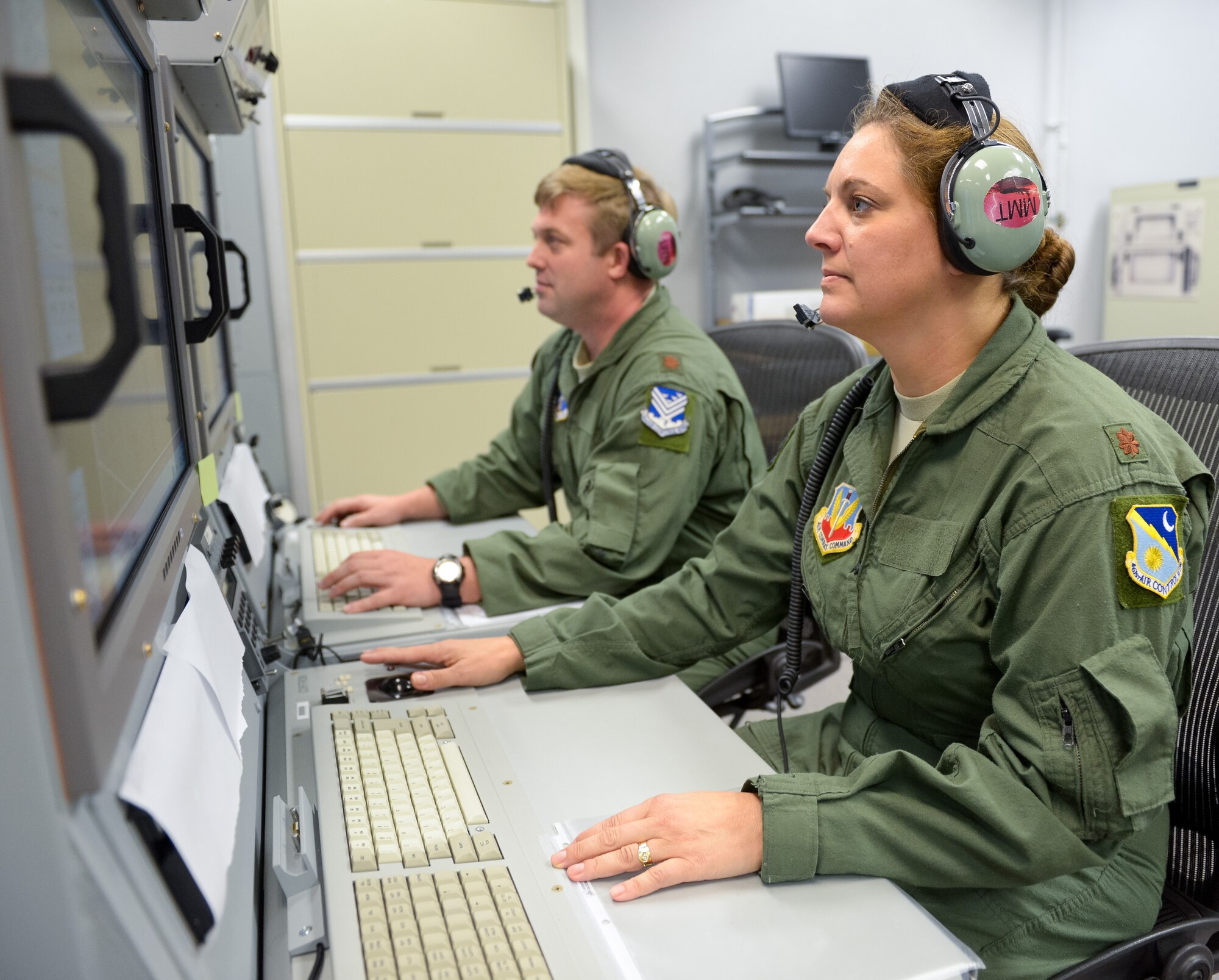 U.S. Air Force Maj. Melody, 461st Operations Support Squadron, and Air National Guard Maj. Sean, 116th Operations Group, monitor data at an operator work station in the Joint STARS mission simulator at Robins Air Force Base, Ga. Team JSTARS reached a milestone logging more than 40,000 training hours in the mission simulator during the past 10 years. (National Guard photo by Master Sgt. Roger Parsons)
