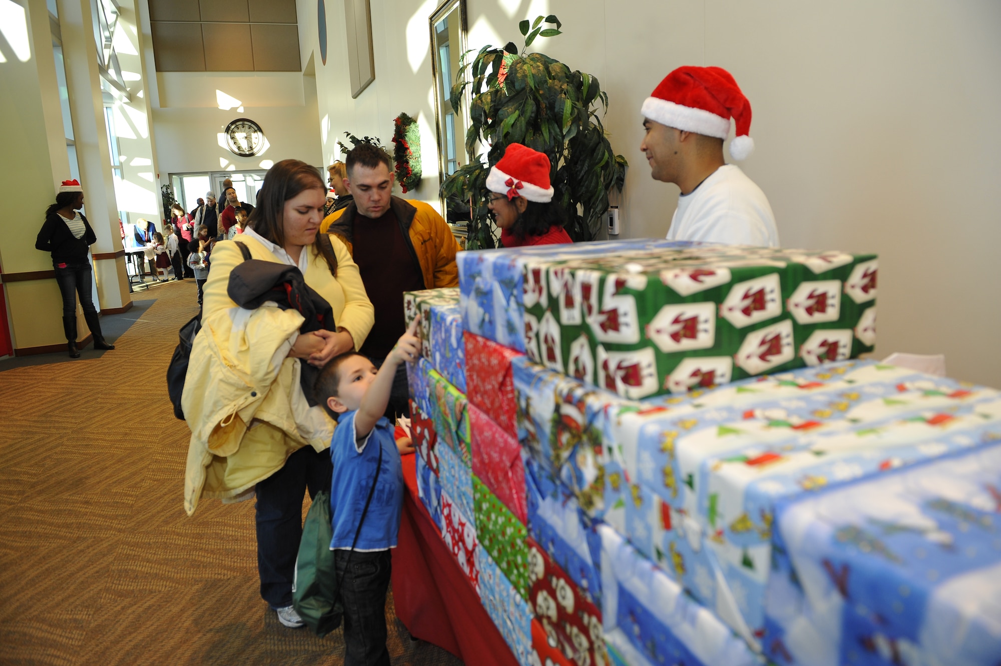 BUCKLEY AIR FORCE BASE, Colo. – Tech. Sgt. Matthew Sullivan, 460th Space Communications Squadron, and his wife, Rebecca, receive a gift Dec 8, 2012, at the Leadership Development Center during the annual Breakfast with Santa event.  Every family that attended received a large gift and each child received an individual present. (U.S. Air Force photo by Airman 1st Class Phillip Houk)