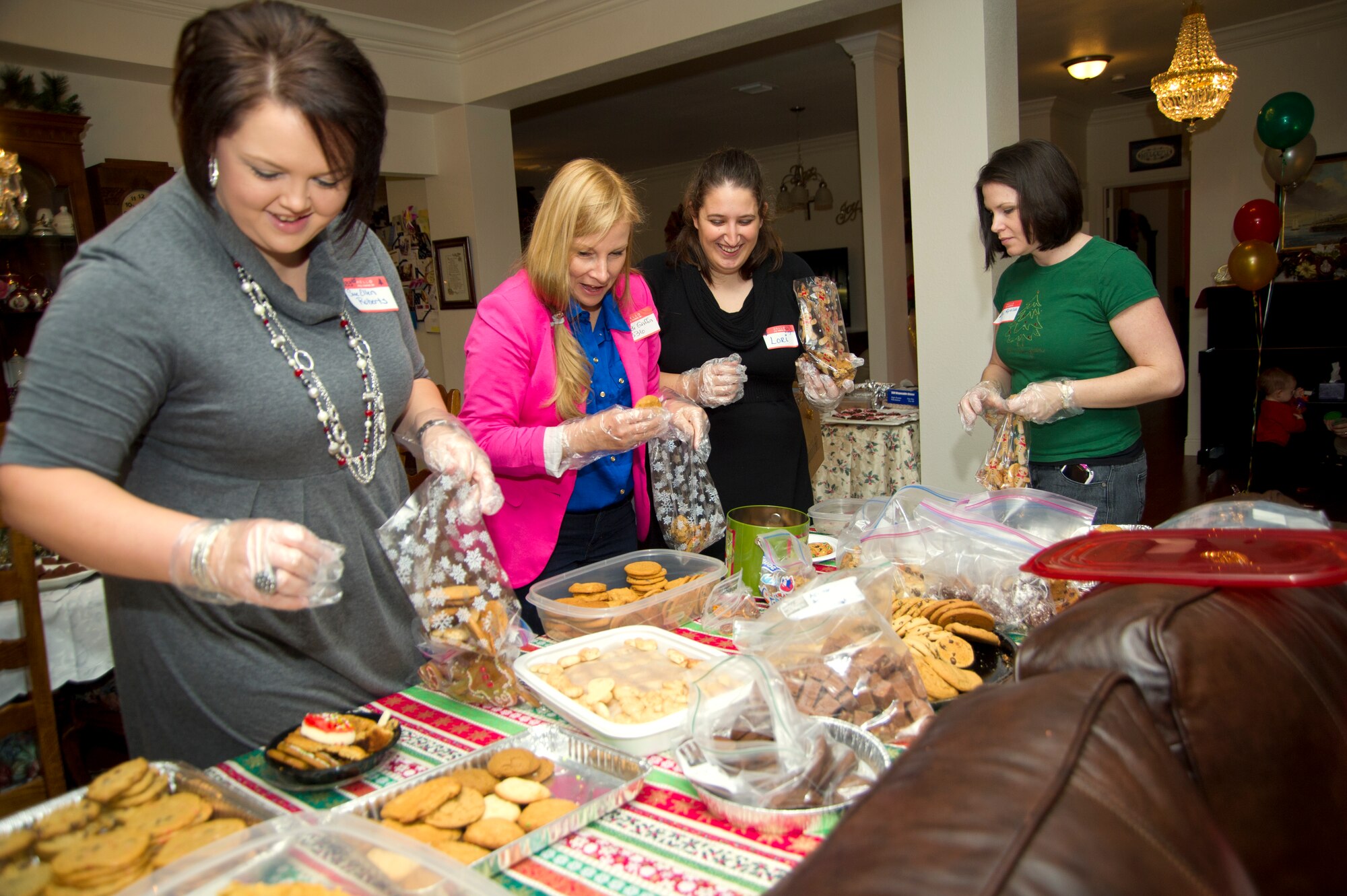 Sue Ellen Roberts, spouse of Capt. Scott Roberts, 333rd Training Squadron; Sandi Griffin, spouse of Lt. Col. Paul Griffin, 336th TRS and Lori Warren, spouse of Staff Sgt. Russell Warren, 338th TRS, fill bags with an assortment of cookies with Linda Worth, spouse of Lt. Col. Brian Worth, 81st Training Group deputy commander, in her Bay Ridge home Dec. 17, 2012, at Keesler Air Force Base, Miss.  Keesler spouses held a cookie exchange and student cookie drive to collect and distribute more than 200 bags of cookies to non-prior service students staying behind over the holidays.  Col. Maureen Smith, 81st TRG commander, will deliver the cookies to students in their dormitories on Christmas Eve.  (U.S. Air Force photo by Adam Bond)