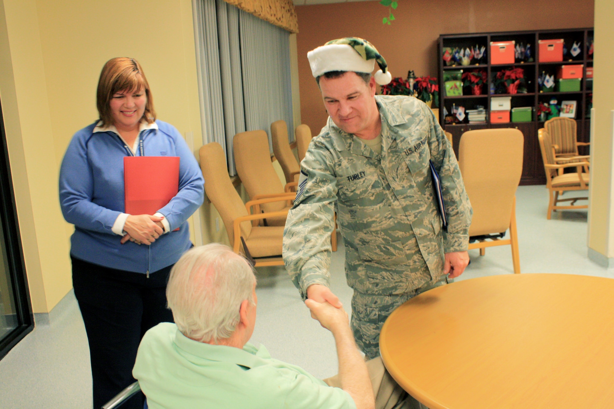 Master Sgt. James Turley, 419th Force Support Squadron, meets a resident of Utah State Veterans Nursing Home in Salt Lake City after the 419th Fighter Wing choir sang Christmas carols. The choir performed at various retirement homes across the Wasatch Front this holiday season. (Courtesy photo)