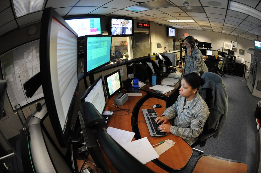 Staff Sgt. Kennecia Williams, 509th Bomb Wing Command Post NCOIC of records, works on the Strategic Automated Command Control system while Staff Sgt. Crystal Salierno, 509th BW/CP training manager, answers a phone call Dec. 11. The Command Post team works throughout the holidays, as well as directed Family Days. (U.S. Air Force photo/Senior Airman Montse Belleau) (Released)