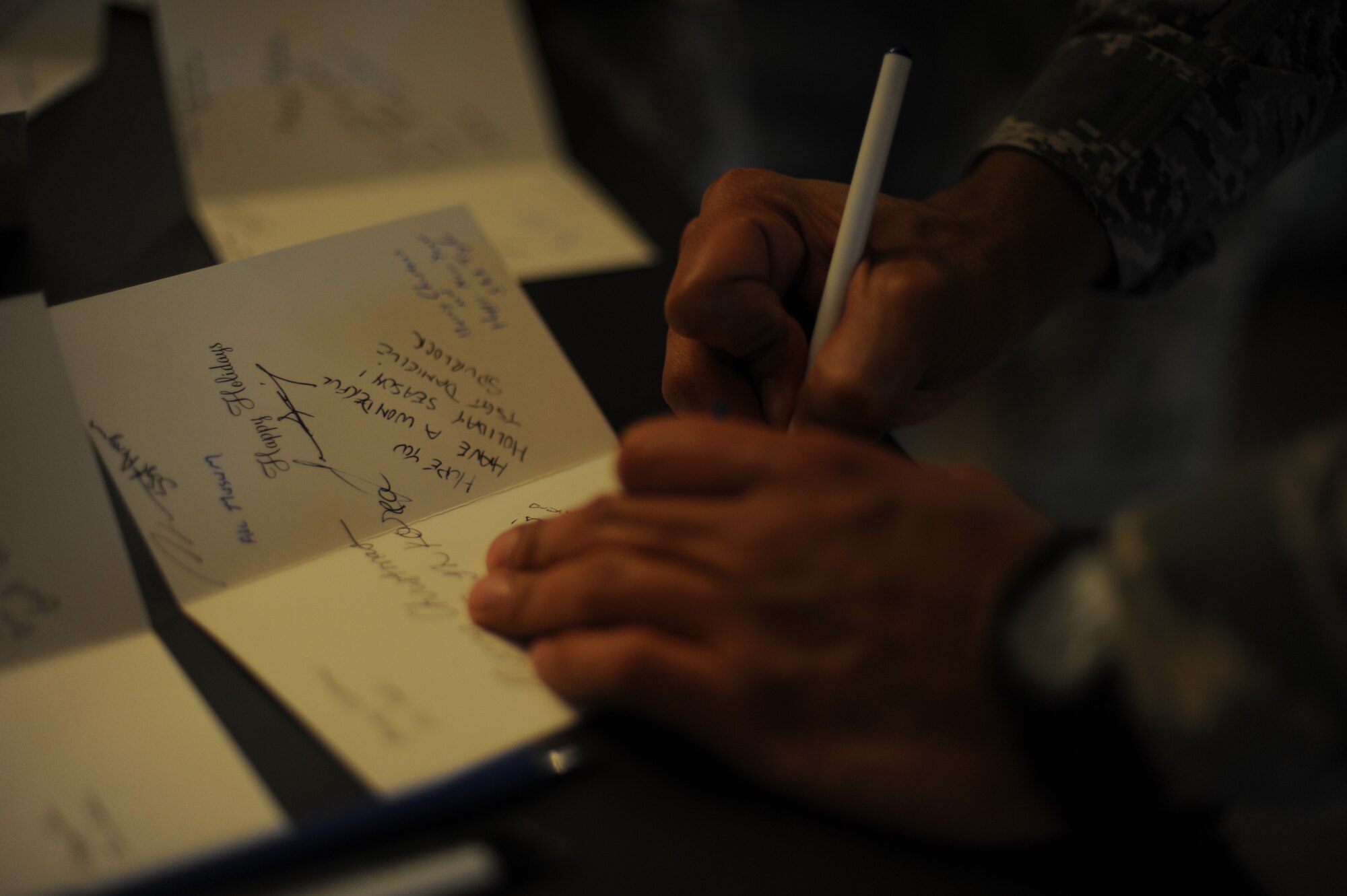 A Hurlburt Airman signs a holiday card while at the Reef Dining Facility at Hurlburt Field, Fla., Dec. 19, 2012. The cards came from the Airmen Committed to Excellence council of Kunsan Air Base, Republic of Korea, and were delivered to the widows of the Air Force Enlisted Village later that night. (U.S. Air Force photo / Senior Airman Joe McFadden)
