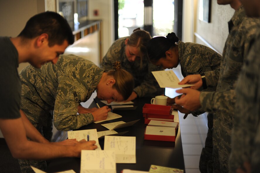 Hurlburt Airmen signed holiday cards while at the Reef Dining Facility at Hurlburt Field, Fla., Dec. 19, 2012. The cards came from the Airmen of Kunsan Air Base, Republic of Korea, and were delivered to the widows of the Air Force Enlisted Village later that night. (U.S. Air Force photo / Senior Airman Joe McFadden)