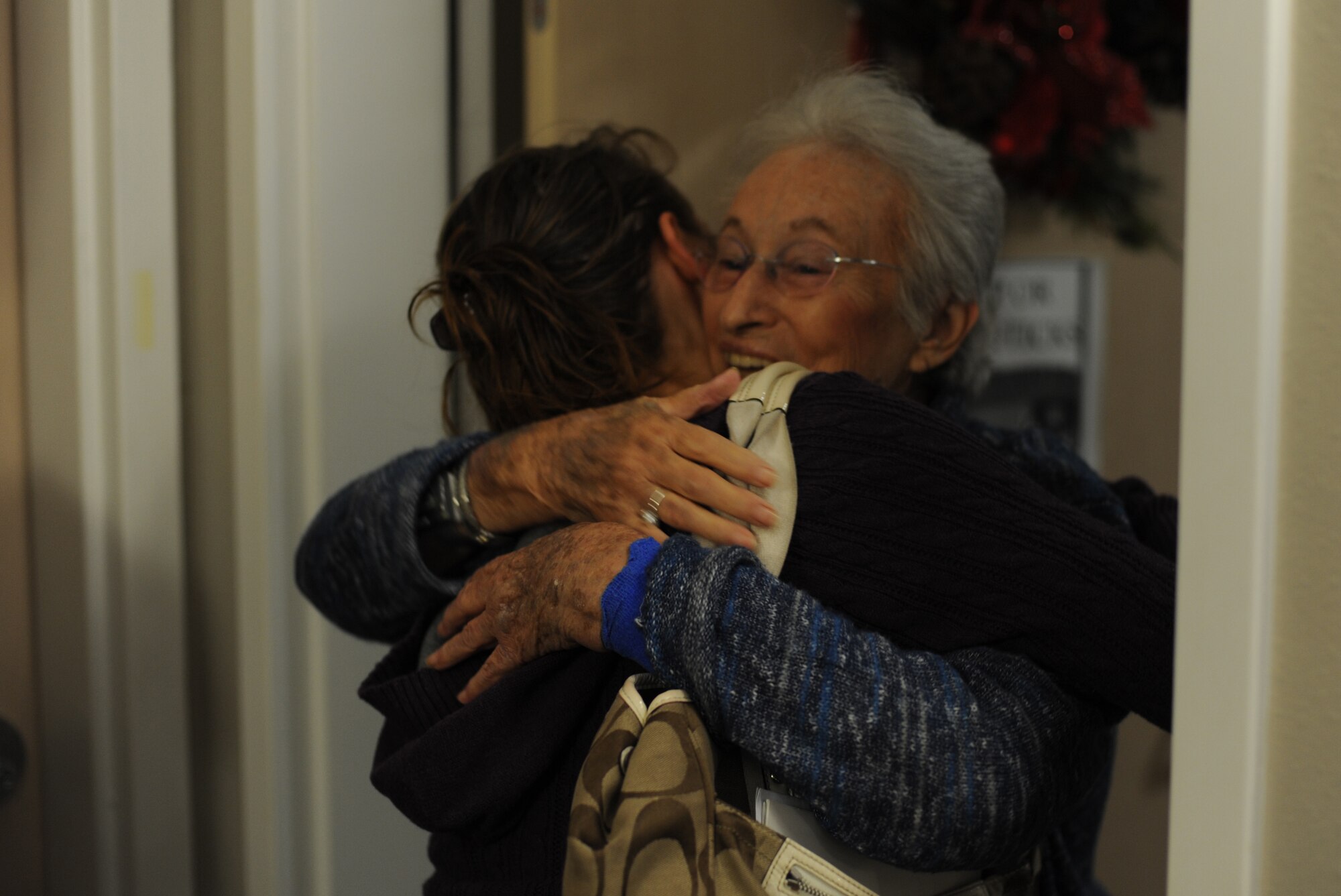 Senior Airman Allison LaPraim, a paralegal of 1st Special Operations Wing Staff Judge Advocate, left, receives a hug from a Hawthorn House resident during a holiday card delivery at the Air Force Enlisted Village in Shalimar, Fla., Dec. 19, 2012. LaPraim and fellow Airmen delivered the cards signed by the junior enlisted forces of Hurlburt Field and Kunsan Air Base, Republic of Korea. (U.S. Air Force photo / Senior Airman Joe McFadden)