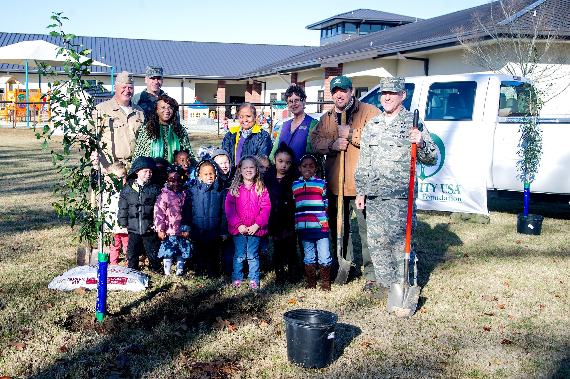 Capt. Thomas Bailey (far left), Keith Thompson (2nd from right), JB Charleston conservation program manager, Chief Master Sgt. Earl Hannon , 628th Air Base Wing command chief(far right), stand with kids and faculty members from the General Thomas R. Mikolajcik Child Development Center during an Arbor Day ceremony Dec. 14, 2012 at Joint Base Charleston - Air Base, S.C. This is the 17th year JB Charleston has been a member of the Tree City USA foundation. To become a Tree City USA member, a community must meet four annual standards: must be a tree protection board or manager, a tree care ordinance, a comprehensive community forestry program, and an Arbor Day observance. Bailey is the Joint Base Charleston deputy commander. (U.S. Air Force photo/Staff Sgt. Rasheen Douglas)