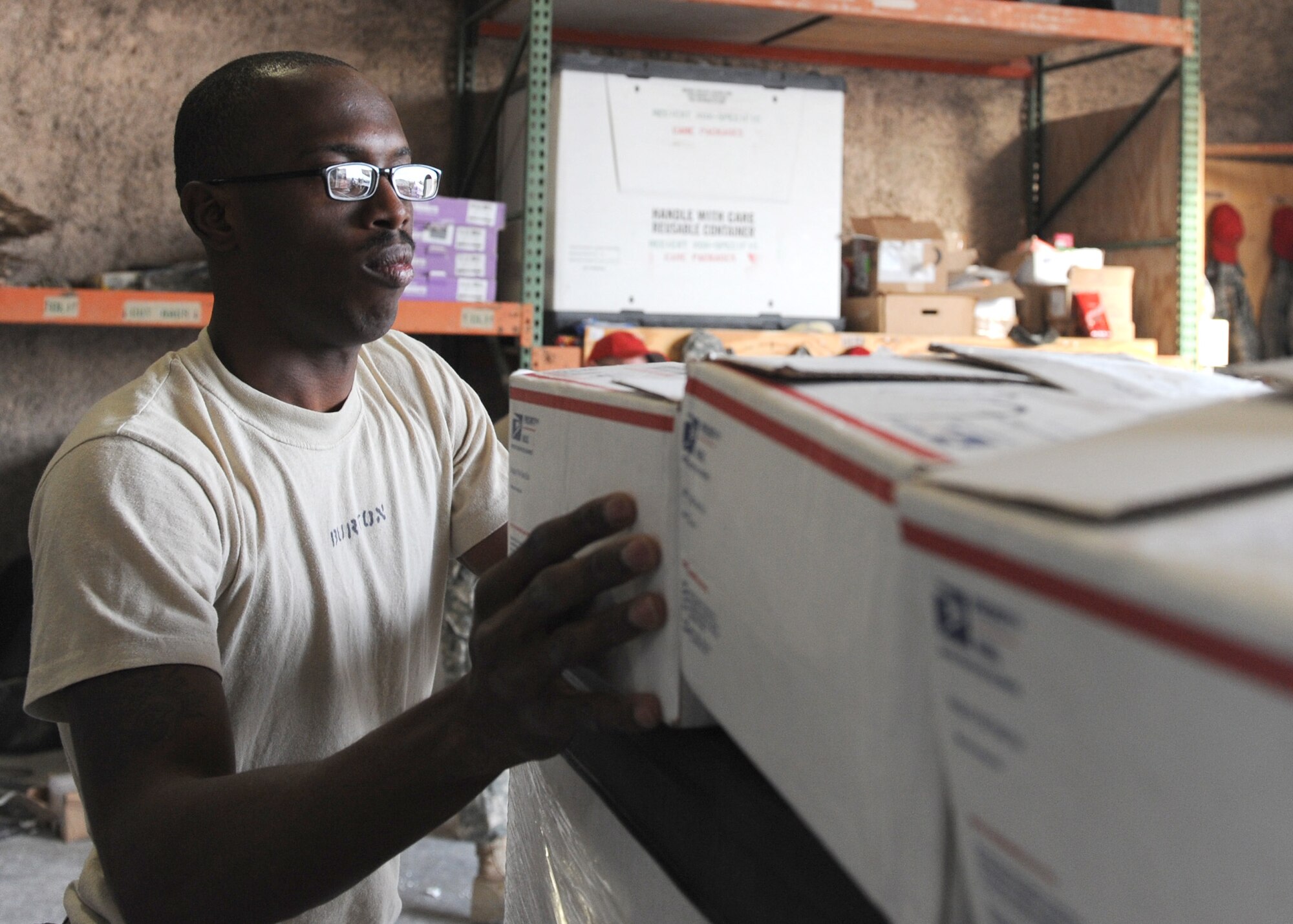 SOUTHWEST ASIA – Army Spc. Neilon Burton, 421st Quartermaster, Det. 4, places care packages from Spokane, Wash., on a pallet, which was later airdropped to service members at forward operating locations in Afghanistan Dec. 12. The packages were sent from a TV station located in Spokane, and were organized for transport downrange by Master Sgt. Patrick Lund, 379th Expeditionary Force Support Squadron. (U.S. Air Force photo/Senior Airman Joel Mease)