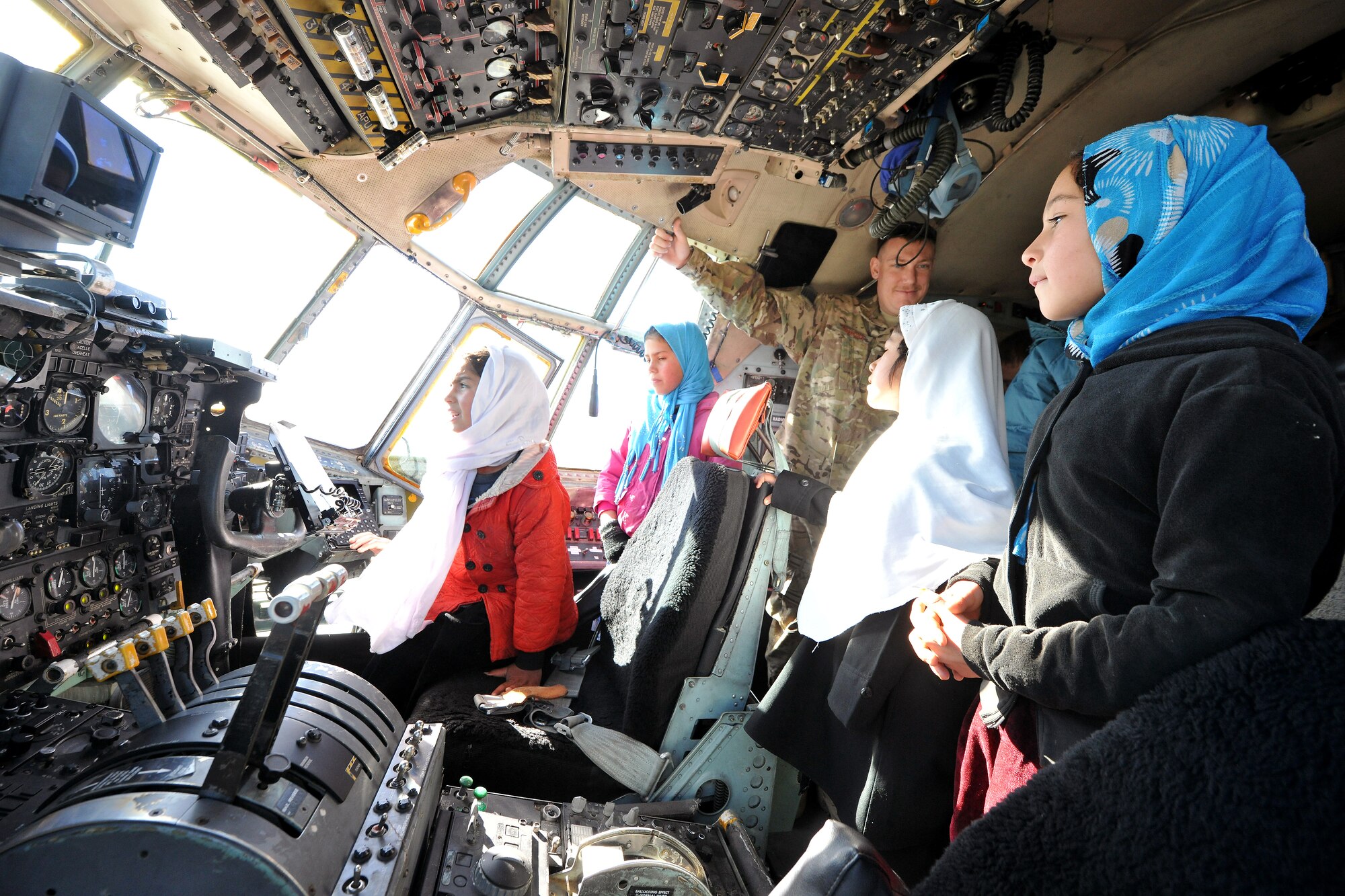 First Lt. Kristian Timmons, 774th Expeditionary Airlift Squadron flight navigator, shows local Afghan girls the flight deck of a C-130 Hercules at Bagram Airfield, Afghanistan, Dec. 20, 2012. The girls are enrolled in the “Cat in the Hat” educational outreach program which supports the International Security Assistance Force’s counter-insurgency efforts by enabling positive interaction between U.S. service members and the local community. (U.S. Air Force photo/Senior Airman Chris Willis)