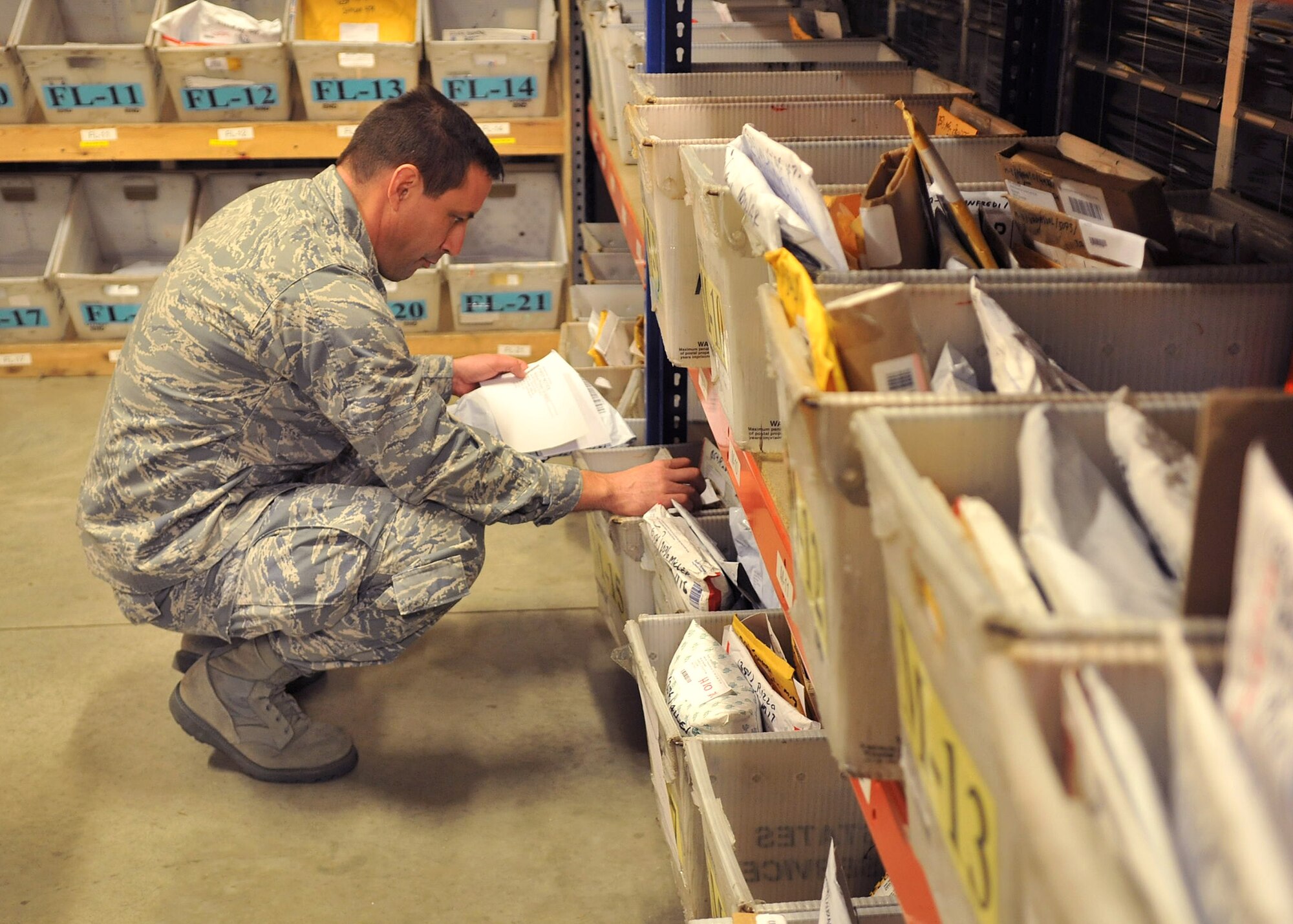 Col. Christopher Kulas, 100th Air Refueling Wing commander, sorts through mail Dec. 19, 2012, at the base post office at RAF Mildenhall, England. Kulas and other volunteeers around the base assisted in sorting and handing out more than 60,000 pounds of mail the base received during this holiday season. (U.S. Air Force photo by Senior Airman Jerilyn Quintanilla/Released)