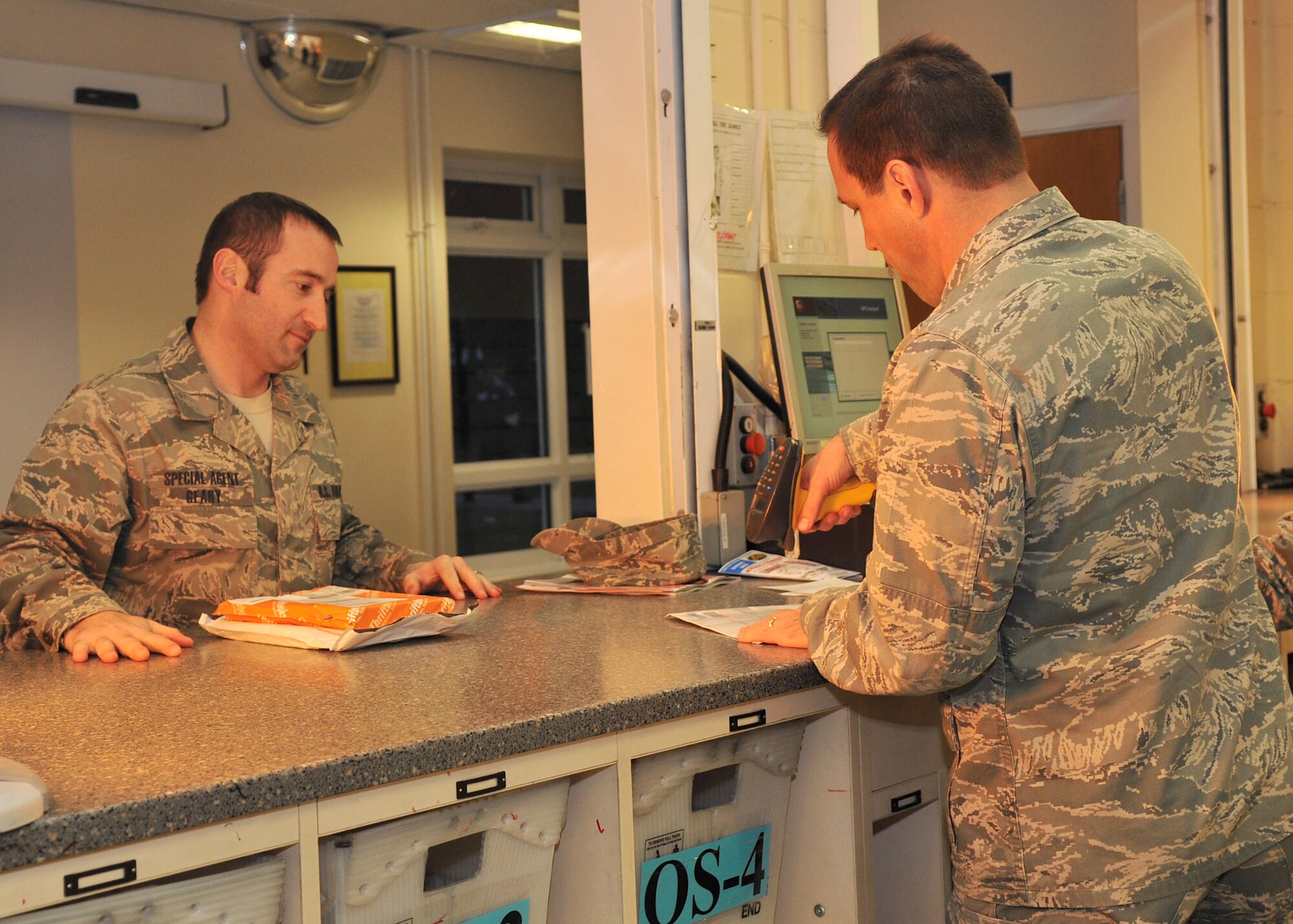 Col. Christopher Kulas, 100th Air Refueling Wing commander, assists a customer Dec. 19, 2012, at the base post office at RAF Mildenhall, England. Kulas was one of more than 60 Airmen around the base who volunteered at the post office to assist with the added workload during the holiday season. (U.S. Air Force photo by Senior Airman Jerilyn Quintanilla/Released)