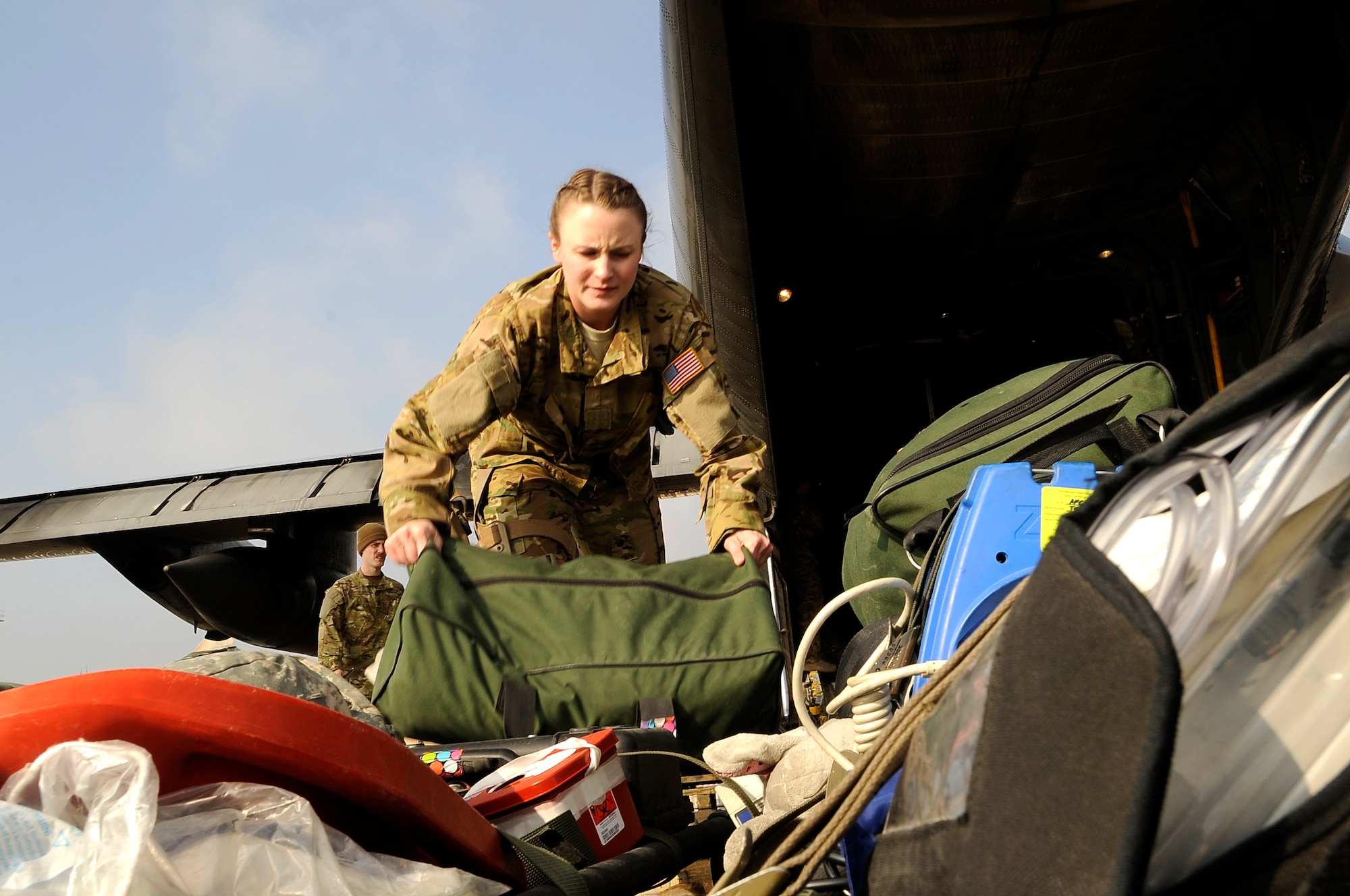 Senior Airman Erin Smith carries medical equipment to a waiting C-130 Hercules here in preparation for a bandage mission” to pick up patients throughout the area of responsibility on Dec. 18, 2012. Smith is a medical technician assigned to the 455th Expeditionary Aeromedical Evacuation Squadron, deployed here from Peterson Air Force Base, Colo. (U.S. Air Force Photo/Master Sgt. Jun Kim)