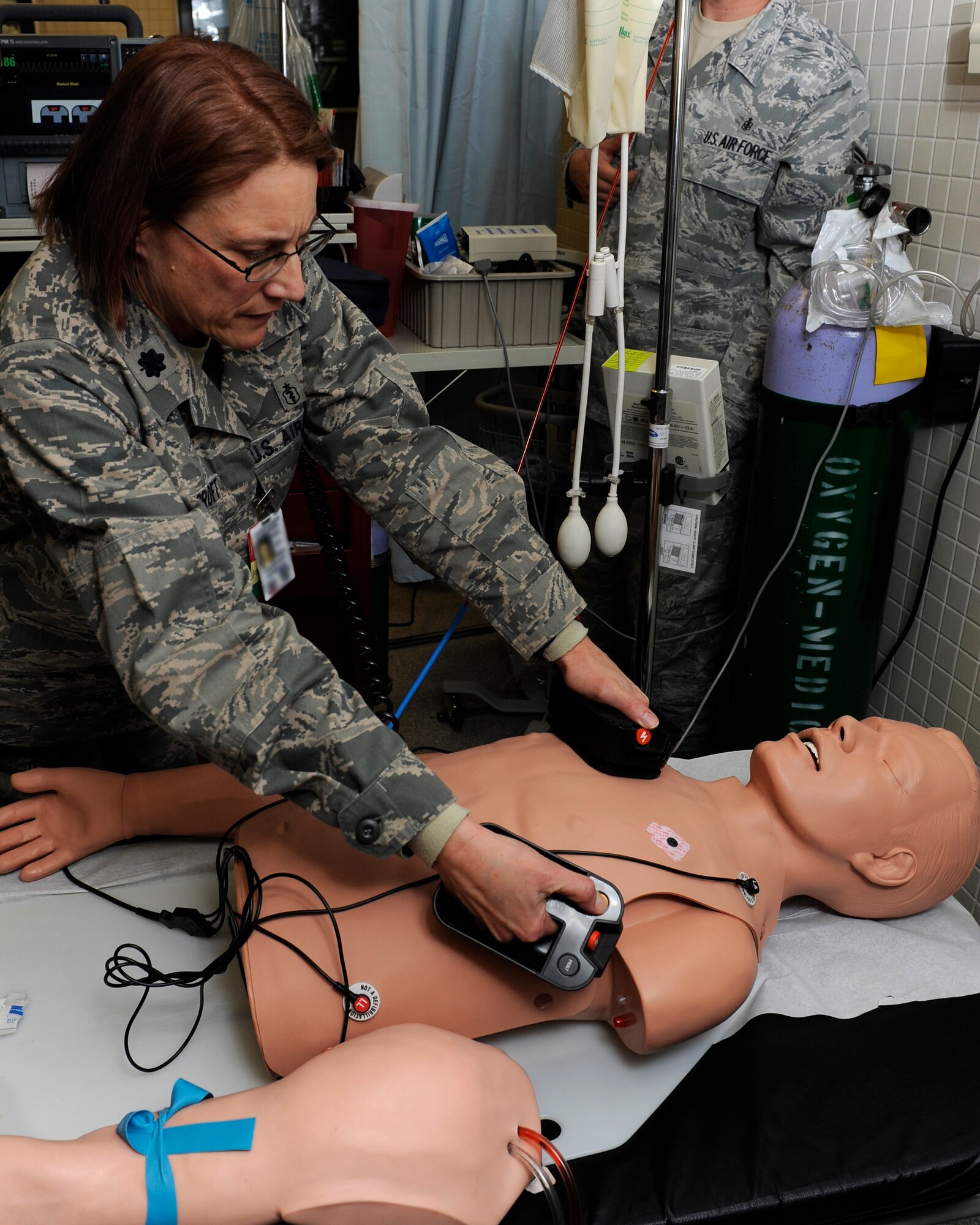 Lt. Col. Jennifer Ravenscroft, 8th Medical Group uses a defibrillator on a training dummy at Kunsan Air Base, Republic of Korea, Dec 11, 2012. During a code blue exercise the 8th MDG administered CPR, defibrillation and IV’s to keep the training dummy stable. (U.S. Air Force photo by Senior Airman Marcus Morris/released)
