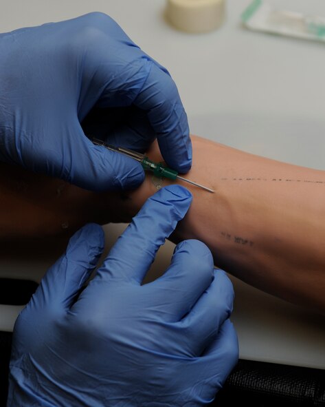 Technical Sgt. Daniel White, 8th Medical Group, sets up an IV in a training dummy on Kunsan Air Base, Republic of Korea, Dec 11, 2012. White set up a dopamine drip for the dummy as part of a cardiorespiratory emergency exercise. (U.S. Air Force photo by Senior Airman Marcus Morris/released)