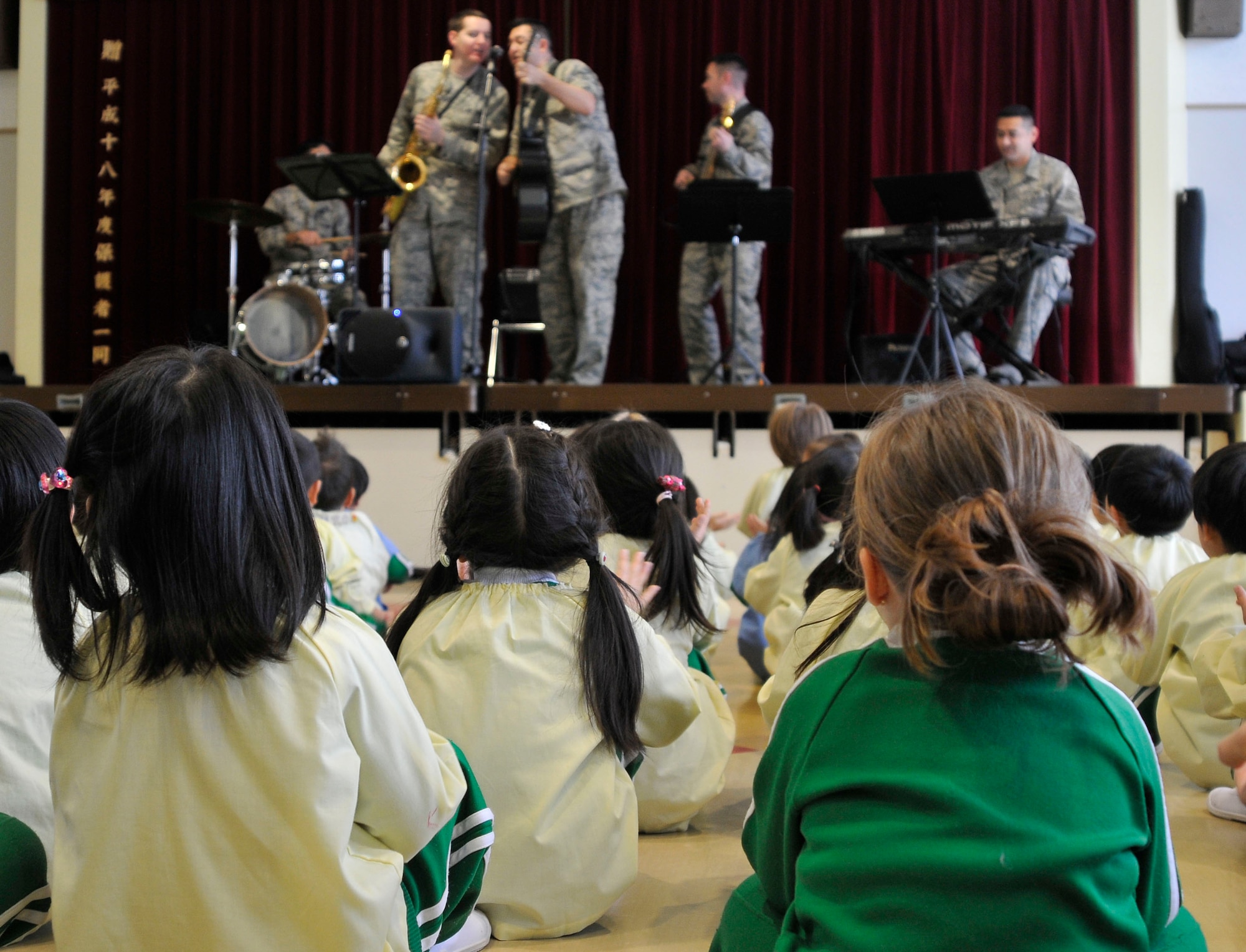 Children from the Misawa Municipal First Preschool listen to the U.S. Air Force Band of the Pacific-Asia Jazz Combo play an arrangement of Christmas songs Dec. 10, 2012, Misawa City, Japan.  After the band’s set, the children presented them with handmade paper medallions as a gift of appreciation.  (U.S. Air Force photo by Tech. Sgt. Phillip Butterfield)