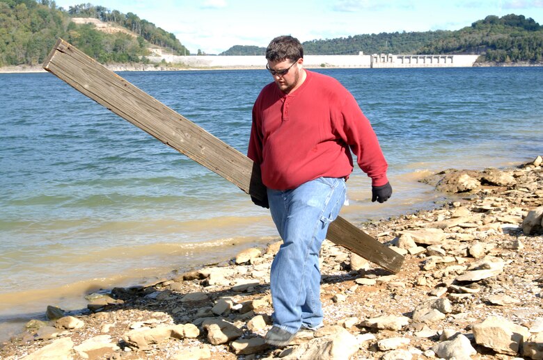 Rob Baulsir, U.S. Army Corps of Engineers Nashville District employee and Leadership Development Program student, carries out a board he found on the shoreline of Center Hill Lake during a National Public Lands Day volunteer event Oct. 1, 2011. (USACE photo by Leon Roberts)