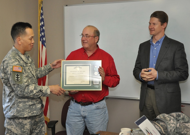 TUCSON, Ariz. -- Col. Mark Toy, the U.S. Army Corps of Engineers Los Angeles District commander, and David Van Dorpe, the District's deputy engineer for programs and project management, present Brian Childers a Commander's Award for Civilian Service during a Dec. 19 meeting at the Tucson Resident Office. Toy thanked Childers for his many years of service and with the work he has done on projects across the District.