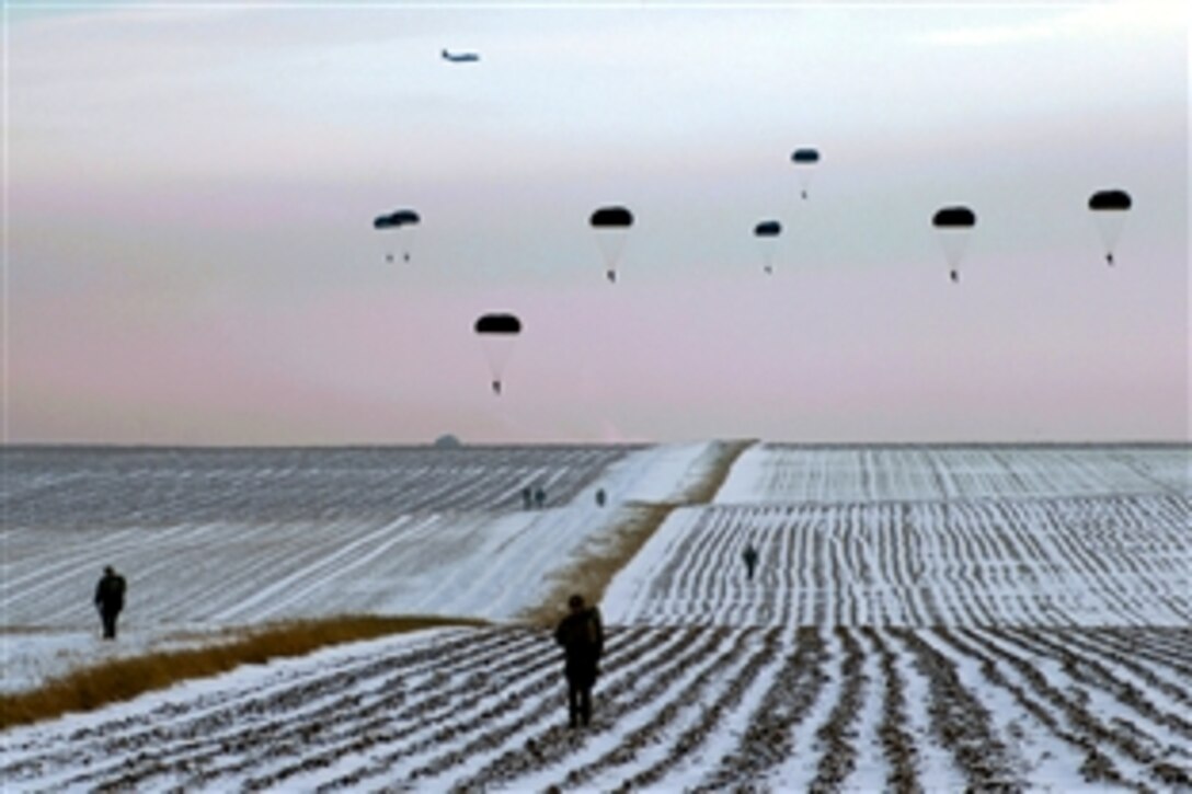 Paratroopers walk from the Alzey drop zone after jumping from a U.S. Air Force C-130 Hercules aircraft during the U.S. Army 5th Quartermaster Detachment's fourth annual Operation Toy Drop  in Alzey, Germany, Dec. 13, 2012. During the event, U.S. soldiers, airmen and paratroopers from Germany, Spain, the Netherlands and Poland jumped from the aircraft to earn foreign jump wings after donating toys to the effort. 